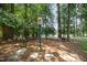 A tranquil backyard retreat with mature trees, a charming sign, and inviting seating perfect for relaxation at 5216 Sunset Fairways Dr, Holly Springs, NC 27540