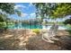 Scenic view of a lake with white rocking chairs inviting peaceful moments by the water's edge at 5216 Sunset Fairways Dr, Holly Springs, NC 27540