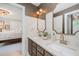 Bright bathroom featuring a double vanity, marble countertops, and a view into the bedroom at 5216 Sunset Fairways Dr, Holly Springs, NC 27540
