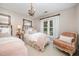 Charming bedroom with two twin beds, a chandelier, and a bright window at 5216 Sunset Fairways Dr, Holly Springs, NC 27540