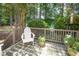 Peaceful deck overlooking a lush backyard, complete with a comfortable white Adirondack chair at 5216 Sunset Fairways Dr, Holly Springs, NC 27540
