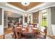 Elegant dining room features a wood table, chandelier, and large windows for ample natural light at 5216 Sunset Fairways Dr, Holly Springs, NC 27540