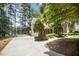 The side view of the house features a long driveway, a lush green lawn, and a picturesque lakeside backdrop at 5216 Sunset Fairways Dr, Holly Springs, NC 27540
