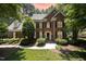 Beautiful brick home with manicured landscaping and a charming front entrance, with a colorful sunset in the background at 5216 Sunset Fairways Dr, Holly Springs, NC 27540