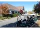 Golf carts parked near a clubhouse with lush landscaping and autumn foliage at 5216 Sunset Fairways Dr, Holly Springs, NC 27540