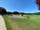 Golf course with clear blue skies featuring golfers, carts and golf equipment at 5216 Sunset Fairways Dr, Holly Springs, NC 27540