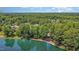 A serene lakefront property with blue lounge chairs, lush trees, and clear blue water at 5216 Sunset Fairways Dr, Holly Springs, NC 27540