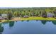 Scenic lake view featuring a gazebo, sandy beach, and picturesque homes nestled amongst lush greenery at 5216 Sunset Fairways Dr, Holly Springs, NC 27540