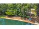 Charming lakefront with a sandy beach, lounge chairs, and lush trees offering a peaceful retreat at 5216 Sunset Fairways Dr, Holly Springs, NC 27540