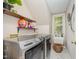 Efficient laundry room with modern washer and dryer, convenient sink, and shelving for supplies at 5216 Sunset Fairways Dr, Holly Springs, NC 27540