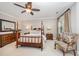 Relaxing bedroom with a four-poster bed, dresser, side tables, and patterned chair at 5216 Sunset Fairways Dr, Holly Springs, NC 27540
