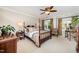 Inviting primary bedroom with a four-poster bed, a ceiling fan, and sunlit windows at 5216 Sunset Fairways Dr, Holly Springs, NC 27540