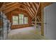 Unfinished attic space showing exposed beams and three windows for natural lighting at 5300 Langdon Dr, Oxford, NC 27565