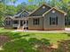 Charming home featuring a covered porch, gray siding, and manicured lawn at 5300 Langdon Dr, Oxford, NC 27565
