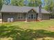Back of home featuring gray siding, windows, and a well-maintained green lawn at 5300 Langdon Dr, Oxford, NC 27565