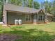 Rear exterior showcasing neutral siding, complemented by a well-maintained lawn at 5300 Langdon Dr, Oxford, NC 27565