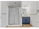 Bathroom featuring a blue vanity, a tiled shower with a glass door, and tile flooring at 5328 Trackway Dr, Knightdale, NC 27545