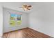 Bright bedroom featuring wood floors, ceiling fan, and large window for ample natural light at 5328 Trackway Dr, Knightdale, NC 27545