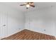Bedroom featuring a ceiling fan, wood floors, and white doors with neutral decor at 5328 Trackway Dr, Knightdale, NC 27545