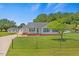 Inviting one-story home featuring blue shutters, well-kept lawn, a detached garage, and extended driveway at 5328 Trackway Dr, Knightdale, NC 27545