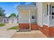 Front porch featuring brick steps, white railings, and an entry door; detached garage in the background at 5328 Trackway Dr, Knightdale, NC 27545