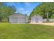 Outbuilding featuring dual garage doors and an extra entrance on a sprawling green lawn at 5328 Trackway Dr, Knightdale, NC 27545