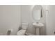 Powder room features a sleek pedestal sink, toilet, and oval mirror at 5430 Crescent Square St, Raleigh, NC 27616