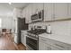 Modern kitchen featuring stainless steel appliances, light gray cabinets, and quartz countertops at 5430 Crescent Square St, Raleigh, NC 27616