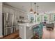 Open kitchen features stainless steel appliances, breakfast bar with stools, and views to the living area at 5430 Crescent Square St, Raleigh, NC 27616