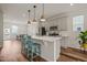 Kitchen boasts pendant lighting, modern cabinetry, stainless appliances, and a breakfast bar with blue stools at 5430 Crescent Square St, Raleigh, NC 27616
