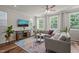 Bright living room featuring a ceiling fan, natural light, hardwood floors, and comfortable seating at 5430 Crescent Square St, Raleigh, NC 27616