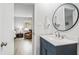 Modern bathroom featuring wood floors, modern vanity, sink, and round mirror at 60 Stoneridge Rd, Durham, NC 27705