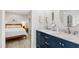Bathroom with double vanity, sinks, mirrors, and access to bright bedroom at 60 Stoneridge Rd, Durham, NC 27705