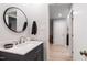 Bathroom featuring a stylish vanity with a round mirror and light gray walls at 60 Stoneridge Rd, Durham, NC 27705