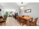Bright dining room with wooden table, chairs, and view into the living room with fireplace at 60 Stoneridge Rd, Durham, NC 27705