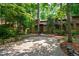 View of home exterior featuring a large driveway surrounded by lush greenery at 60 Stoneridge Rd, Durham, NC 27705