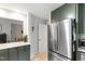The renovated kitchen features modern stainless steel appliances and olive drab colored cabinets at 60 Stoneridge Rd, Durham, NC 27705