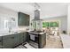 Bright kitchen with stainless steel appliances and stylish green cabinets with deck access at 60 Stoneridge Rd, Durham, NC 27705