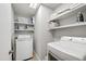 Functional laundry room with two sets of appliances and ample shelving for storage at 60 Stoneridge Rd, Durham, NC 27705