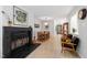 Open-concept living room featuring a black brick fireplace, modern furniture, and light wood floors at 60 Stoneridge Rd, Durham, NC 27705