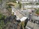 Aerial view of complex featuring multiple townhomes near community pond and woods at 610 Walnut Woods Dr, Morrisville, NC 27560