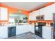 Bright kitchen featuring white cabinets, stainless steel microwave, black appliances, and hardwood flooring at 610 Walnut Woods Dr, Morrisville, NC 27560