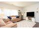 Cozy living room featuring plush couches, a large rug, and a sliding glass door that lets in natural light at 610 Walnut Woods Dr, Morrisville, NC 27560