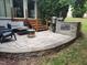 Outdoor patio boasts stone-built grill, wood stairs to deck, and comfortable seating at 610 Walnut Woods Dr, Morrisville, NC 27560
