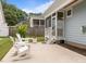 Backyard patio featuring white Adirondack chairs, a table, and access to the screened porch at 622 Sunset Ave, Apex, NC 27502