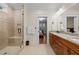 Bright bathroom featuring a double vanity with granite countertop, framed mirror, and tiled shower with glass door at 622 Sunset Ave, Apex, NC 27502