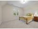 Cozy bedroom with a metal bed frame, carpeted floors, and natural light from the window at 622 Sunset Ave, Apex, NC 27502