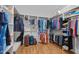 Spacious walk-in closet with custom shelving, hanging rods, and wood floors providing ample storage at 622 Sunset Ave, Apex, NC 27502