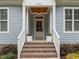 Inviting front entrance with brick steps, decorative plants, and charming overhead light fixture at 622 Sunset Ave, Apex, NC 27502