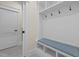 Mudroom with a built-in bench with blue cushion, hooks, and cubbies for storage and organization at 622 Sunset Ave, Apex, NC 27502